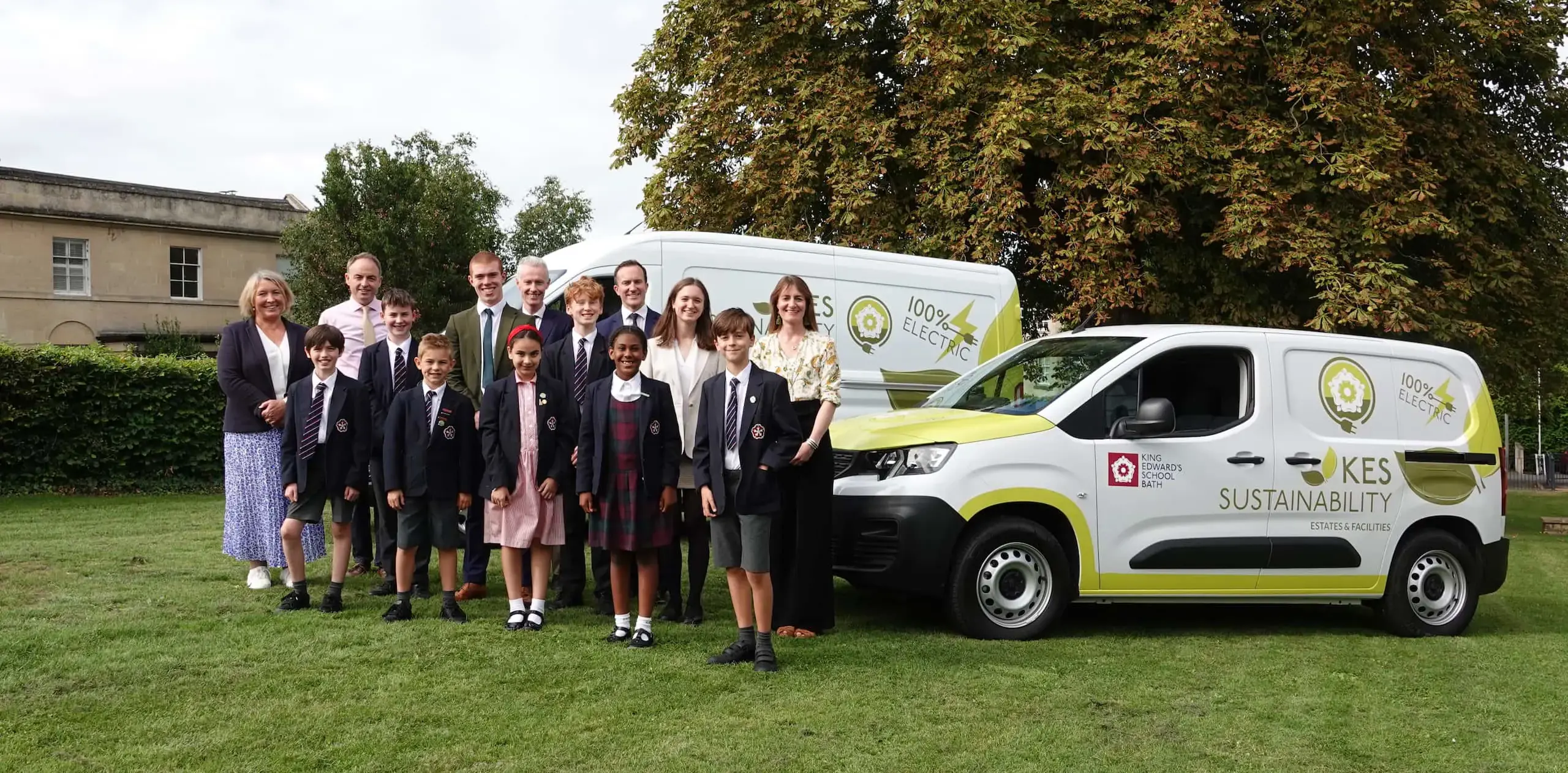 Group of pupils and teachers standing around KES electric vehicles