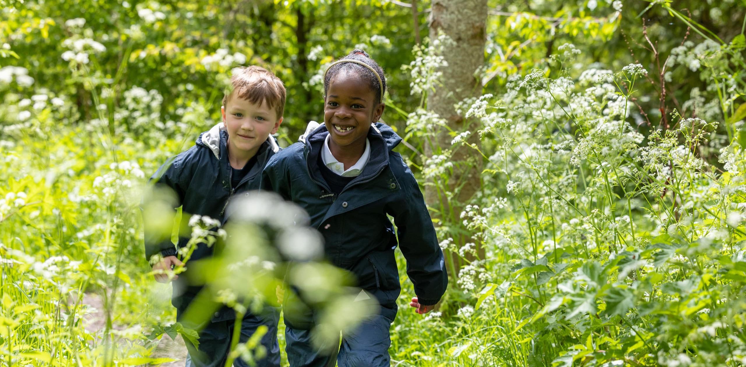 Two students walking in forest